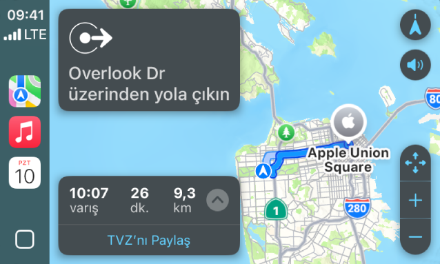 Kenar çubuğunda Harita, Müzik ve Takvim uygulamalarını gösteren CarPlay. Sağ tarafta, Apple Park’tan Apple Union Station’a bir navigasyon güzergâhı var.