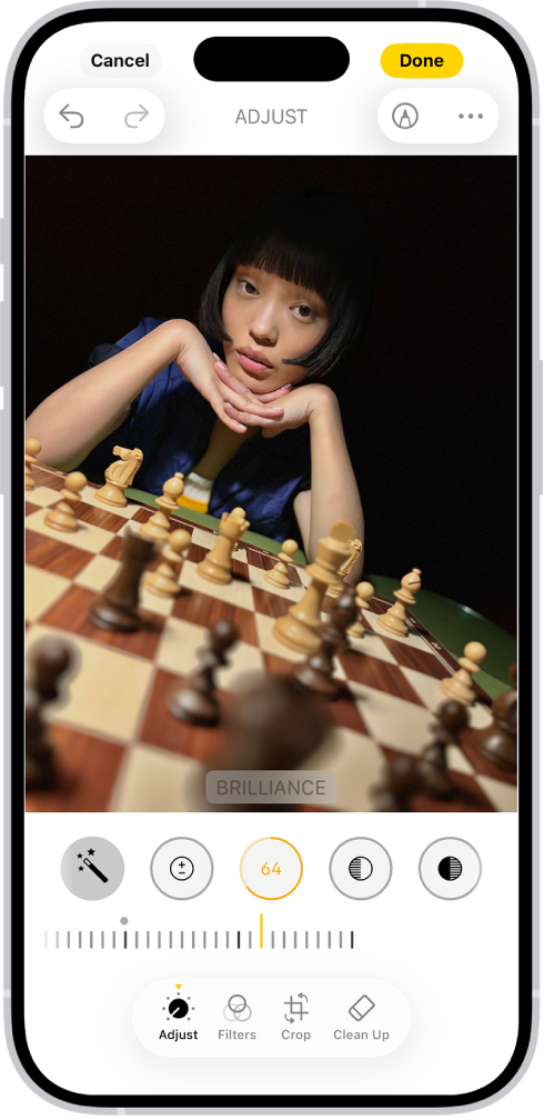 중앙에 사진이 있는 편집 화면. 화면 하단에는 왼쪽에서 오른쪽으로 조절, 필터, 자르기 및 클린업 버튼이 있음. 조절 버튼이 선택되어 있고, 휘도를 조절할 수 있는 슬라이더가 있음. 화면 왼쪽 상단 모서리에는 취소 버튼이 있고, 오른쪽 상단 모서리에는 완료 버튼이 있음.