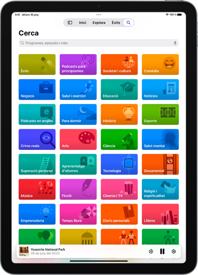 La pantalla de cerca està oberta a l’app Pòdcasts i mostra categories de pòdcasts. A la part inferior de la pantalla hi ha la il·lustració i el títol de l’episodi i els botons “Retrocedeix”, “Pausa” i “Avança”.
