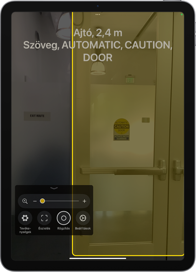 A megnyitott Nagyító app egy észlelt ajtóval. Egy leírás bemutatja, hogy milyen messze található az ajtó, illetve azt, hogy milyen szöveg látható rajta.
