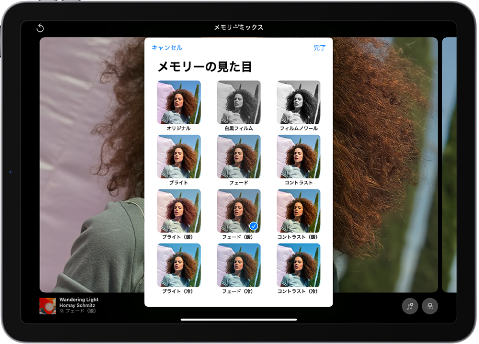 画面の中央でメモリーが再生されています。画面の下部には、左から順に、「メモリーミックス」、「写真」、「ムービー」の各ボタンがあります。右上には、音量、その他、閉じるの各ボタンがあります。左上には、メモリーのタイトル、再生中の曲名とアーティスト名が表示されています。