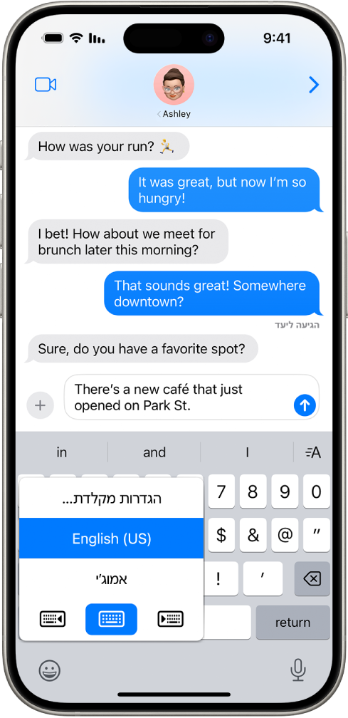 תפריט ״הגדרות מקלדת״ פתוח ומציג שלוש אפשרויות: ״אנגלית (ארה״ב)״, ״אמוג׳י״ ו״משוב הקלדה״. בתחתית התפריט, מימין לשמאל, מופיעים כפתורים עבור פריסת מקלדת לשמאליים, פריסת מקלדת של ברירת מחדל ופריסת מקלדת לימניים. הכפתור של פריסת המקלדת של ברירת המחדל נבחר.