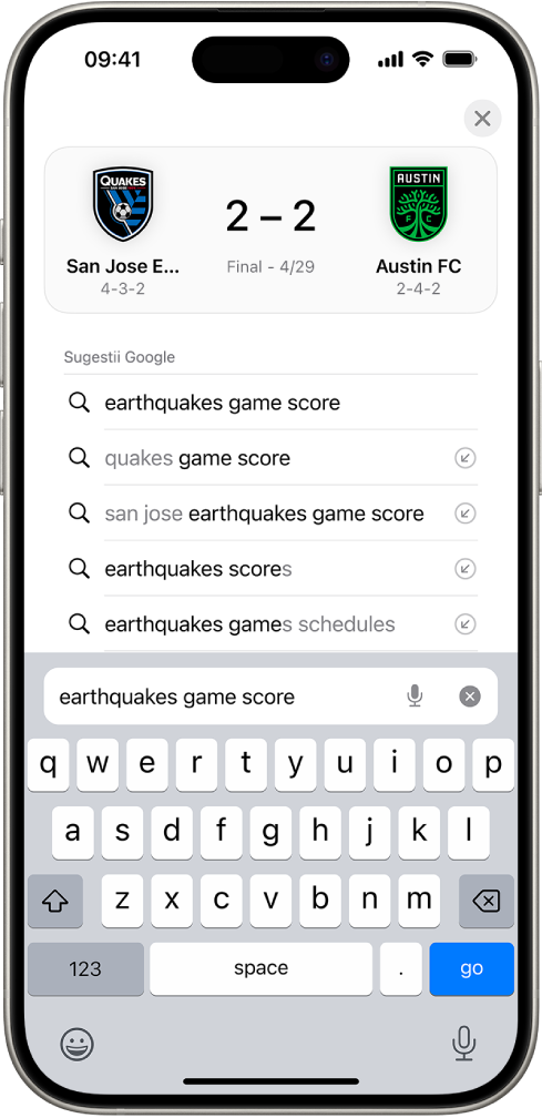Un ecran de căutare din Safari, cu tastatura de ecran în partea de jos. Deasupra tastaturii, câmpul de căutare conține textul “earthquakes game score.”