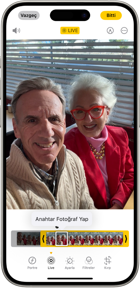 Fotoğraflar uygulamasında bir Live Photo açık. Fotoğrafın altında kare görüntüleyici bulunuyor; Anahtar Fotoğraf Yap düğmesi etkin. Kare görüntüleyicinin her iki ucunda da Live Photo’yu kısaltmanızı sağlayan iki ok var. Ekranın en altında Portre, Live, Ayarla, Filtreler ve Kırp düğmeleri bulunuyor. Live düğmesi seçili.