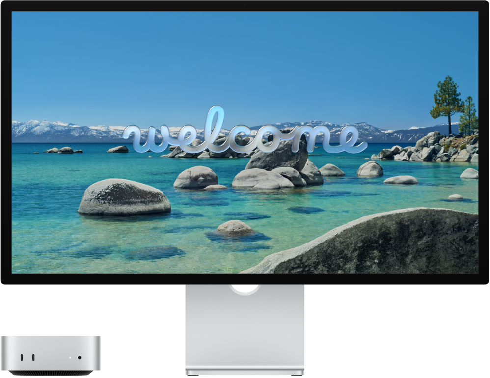 „Mac mini“ ir „Studio Display“ vienas šalia kito, ekrane matomas žodis „Welcome“ (sveiki).