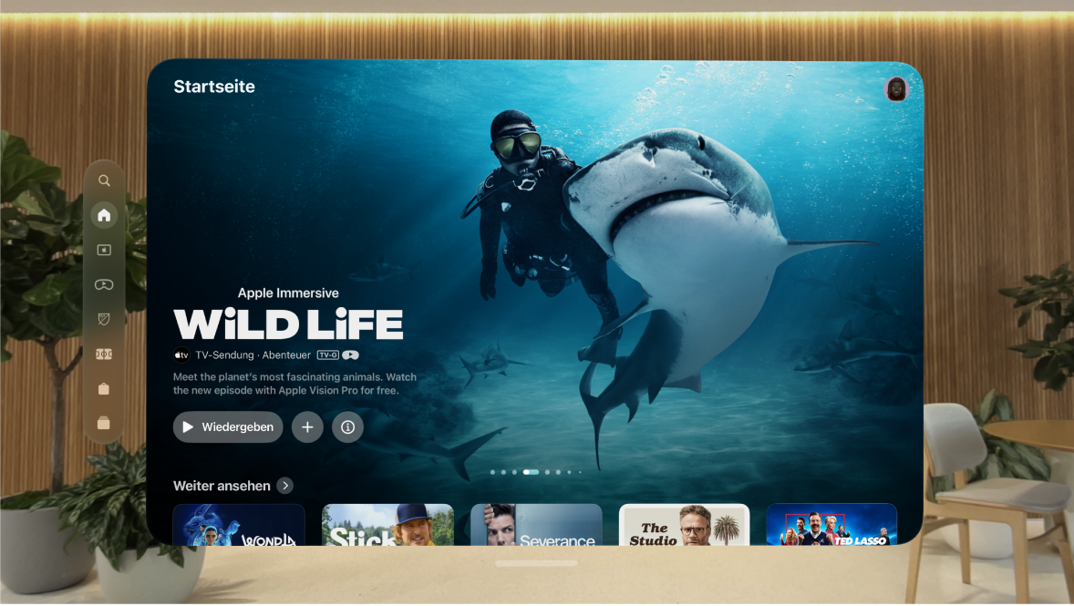 Die Apple TV App auf der Apple Vision Pro mit dem Tab „Home“. Einige Sendungen sind sichtbar, die ausgewählt werden können.