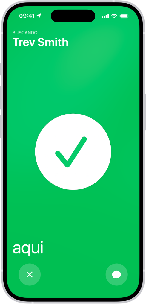 A tela do iPhone está verde, com uma grande marca de seleção no centro. O nome da pessoa sendo localizada está no canto superior esquerdo e a palavra “aqui” aparece no canto inferior esquerdo, indicando que o encontro foi bem-sucedido.