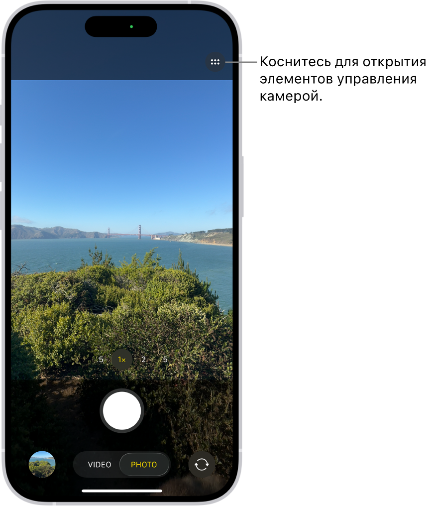 Открыто приложение «Камера» в режиме «Фото». Кнопка элементов управления камерой находится в правом верхнем углу. Кнопка просмотра снятых фото и видео находится в левом нижнем углу. Кнопка съемки фото расположена по центру в нижней части экрана, а кнопка выбора камеры на задней панели — в правом нижнем углу.