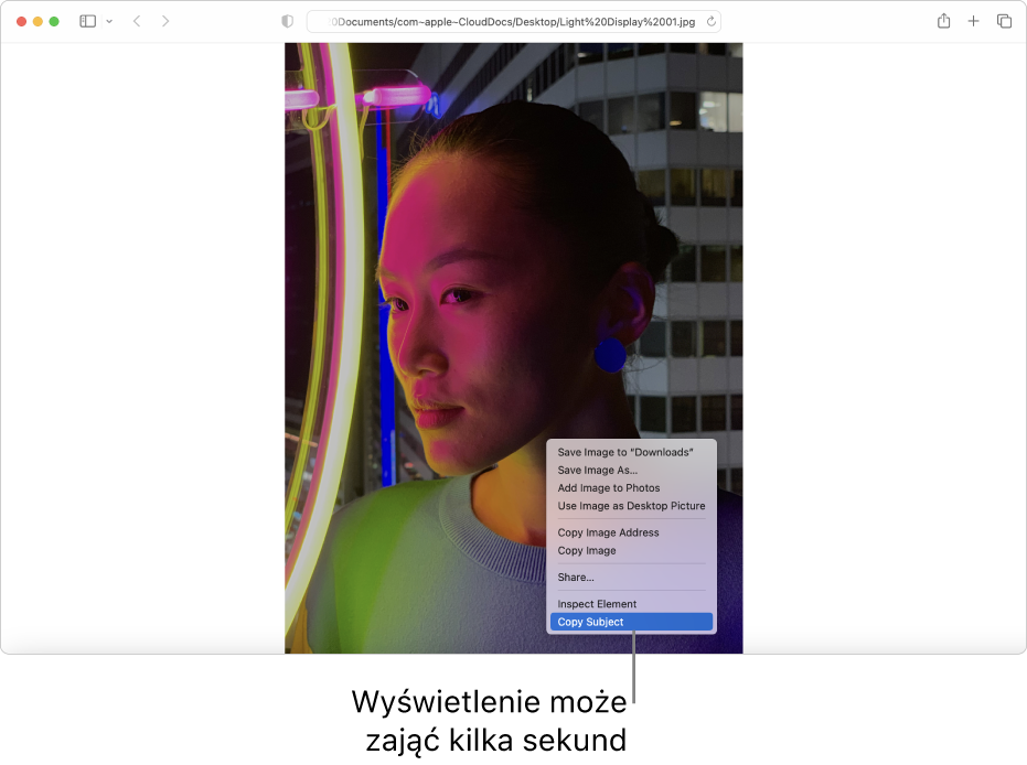Obrazek w Safari przedstawiający osobę ze światłami i budynkiem w tle.