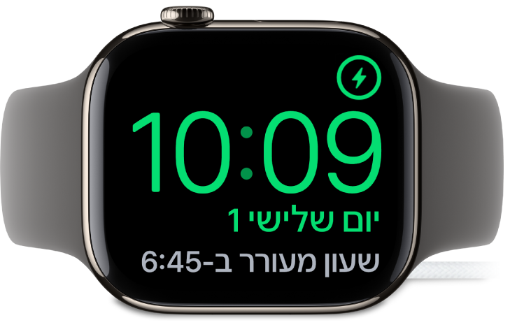 שעון Apple Watch מונח על צידו ומחובר למטען. המסך מציג את סמל הטעינה בפינה הימנית העליונה, ומתחתיו את השעה הנוכחית ואת השעה שבה יצלצל השעון המעורר הבאה.
