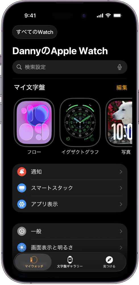 iPhoneのApple Watchアプリの「マイウォッチ」画面が開いています。上部に文字盤、その下に各種の設定が表示されています。Apple Watchアプリ画面の下部には3つのタブがあります。左の「マイウォッチ」タブは、Apple Watchの設定に移動します。次の「文字盤ギャラリー」では、使用できる文字盤とコンプリケーションを見て回ることができます。その次の「見つける」では、Apple Watchの詳細を確認できます。