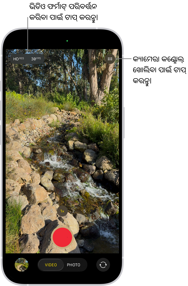 କ୍ୟାମେରା ଭିଡିଓ ମୋଡ୍ରେ ଅଛି। କ୍ୟାମେରା କଣ୍ଟ୍ରୋଲ୍ ବଟନ୍ ଶୀର୍ଷ-ଡାହାଣ କୋଣରେ ଅଛି ଏବଂ ଭିଡିଓ ଫର୍ମାଟ୍ ବଟନ୍ ଶୀର୍ଷ-ବାମ କୋଣରେ ଅଛି। ଫଟୋ ଏବଂ ଭିଡିଓ ଭ୍ଯୁୟର୍ ବଟନ୍ ନିମ୍ନ-ବାମ କୋଣରେ ଅଛି। ରେକର୍ଡ୍ ବଟନ୍ ନିମ୍ନ ଭାଗ ମଝିରେ ଅଛି ଏବଂ କ୍ଯାମେରା ଚୁଜର୍ ବ୍ଯାକ୍-ଫେସିଂ ବଟନ୍ ନିମ୍ନ-ଡାହାଣ କୋଣରେ ଅଛି।