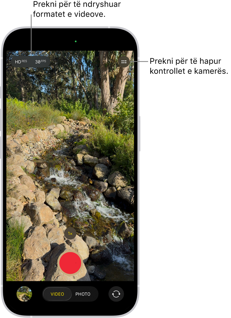 Camera në modalitetin Video. Butoni Camera Controls është në këndin sipër djathttas dhe butonat e formatit të videos janë në këndin sipër majtas. Butoni Photo and Video Viewer ndodhet në këndin majtas poshtë. Butoni Record është në pjesën e poshtme qendrore, dhe butoni Camera Chooser Back-Facing është në këndin e poshtëm djathtas.