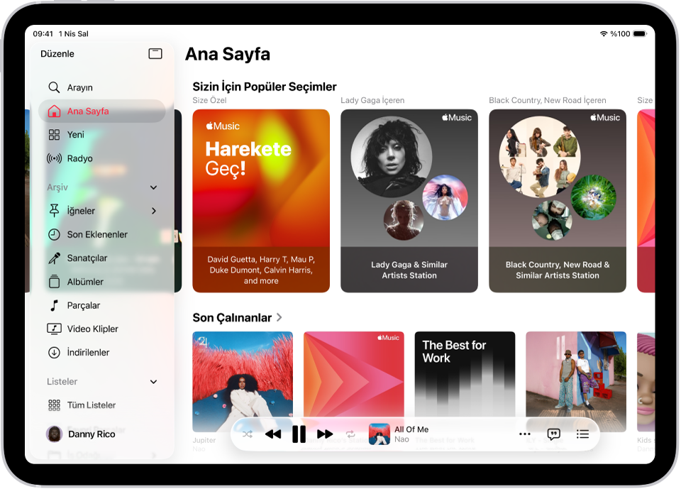 Müzik uygulamasının Ana Sayfa sekmesi, sol tarafta kenar çubuğunu, sağ tarafta ise Ana Sayfa bölümünü gösteriyor. En üstte Popüler Seçimler’i gösteren Ana Sayfa sekmesi. Alt tarafta son çalınan müzikler görünüyor ve dört albüm kapağı gösteriliyor. Mini çalar en altta.