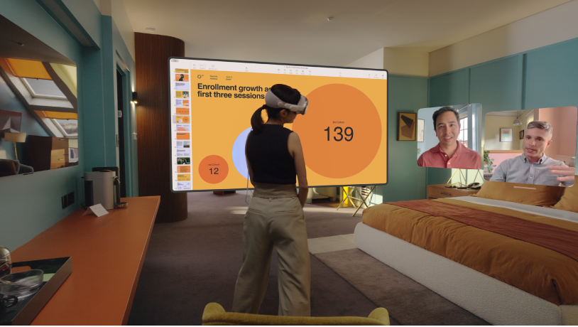 Apple Vision Pro를 착용하고 FaceTime 통화 중인 한 사람. 공유 화면 옆에 통화 상대방의 타일이 표시됨.