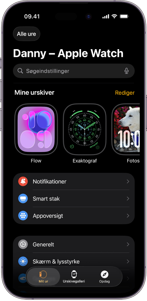 Appen Watch på iPhone med skærmen Mit ur, hvor der vises urskiver øverst og indstillinger nedenunder. Der er tre faner nederst på skærmen i appen Watch: Fanen til venstre er Mit ur, som du bruger til indstilling af Apple Watch. Den næste er Urskivegalleri, hvor du kan se de tilgængelige urskiver og komplikationer, og så kommer fanen Opdag, hvor du kan få mere at vide om Apple Watch.