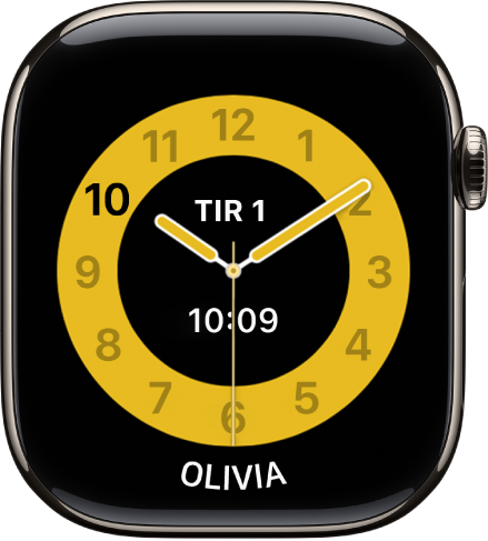 Skoletid-urskiven som viser en analog klokke med dato og digitalt klokkeslett ved midten. Nederst er navnet på barnet som bruker klokken.