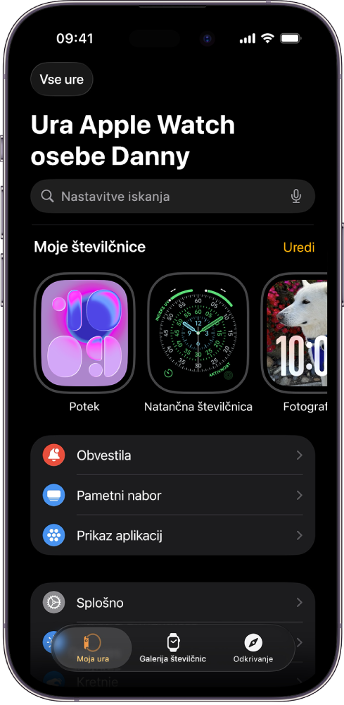 Aplikacija za Apple Watch v iPhonu z odprtim zaslonom Moja ura, na katerem so na vrhu številčnice in spodaj nastavitve. Na dnu zaslona aplikacije Apple Watch so trije zavihki: levi zavihek je Moja ura, kjer najdete nastavitve za Apple Watch; naslednji je Galerija številčnic, kjer lahko izberete številčnice in komplikacije, ki so na voljo; nato je Odkrivanje, kjer lahko izveste več o uri Apple Watch.