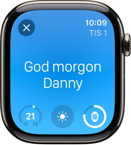 Apple Watch med väckningsskärmen. Överst står det God morgon. Temperaturen, väderförhållanden och batterinivån visas nedanför.