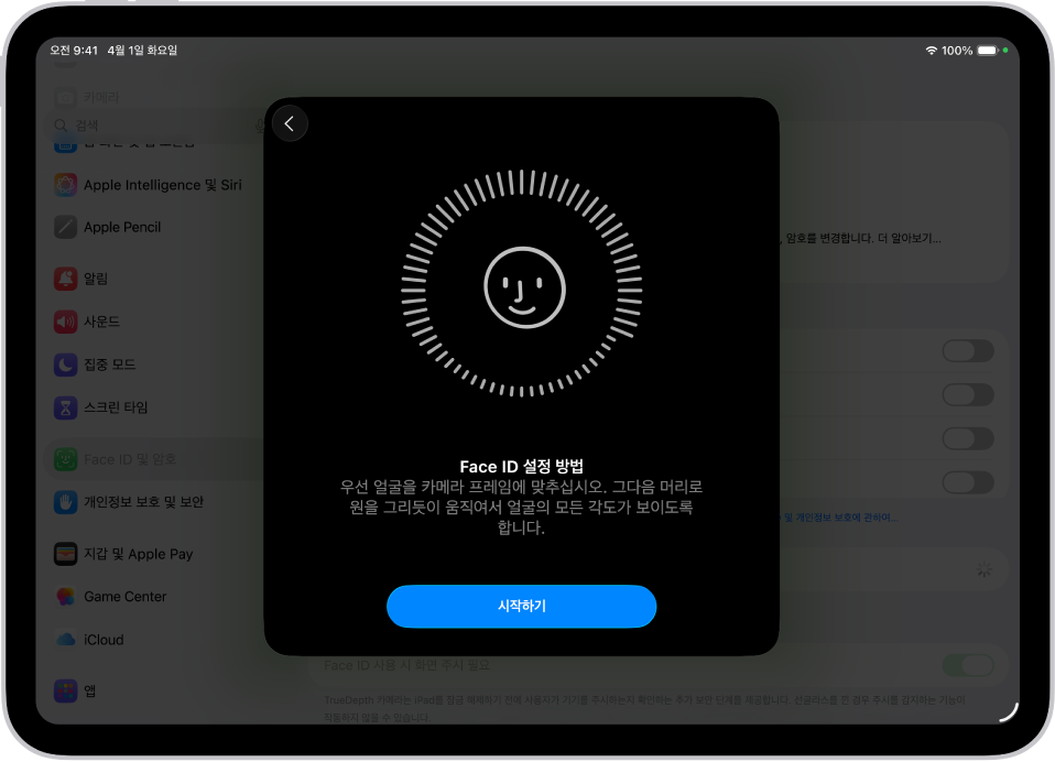 Face ID 인식 설정 화면. 원형 프레임 안에 웃는 얼굴이 있는 화면이 표시됨. 아래에는 사용자에게 천천히 머리를 움직여 원을 완성하라는 지침이 표시된 텍스트가 있음. 화면의 하단 근처에 시작하기 버튼이 나타남.