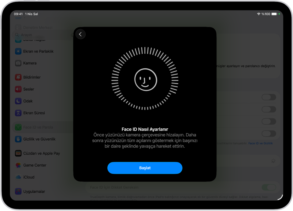 Face ID tanıma ayarlama ekranı. Ekranda, daire içine alınmış bir gülen yüz gösteriliyor. Altındaki metin, kullanıcıya daireyi tamamlamak için kafasını yavaşça hareket ettirmesini söylüyor. Ekranın alt tarafında Başla düğmesi görünüyor.