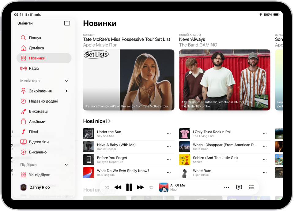 Вкладка «Новинки» з бічною панеллю зліва й розділом «Новинки» справа. Угорі вкладки «Новинки» показано обрану музику. Проведіть вліво, щоб переглянути більше обраних пісень і відео. Унизу відображається розділ «Останні пісні». Мініпрогравач розташовано внизу.