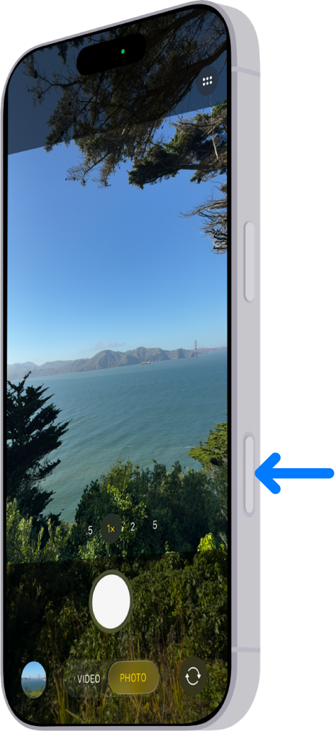 Una fletxa assenyala la ubicació del control de càmera al lateral de l’iPhone.