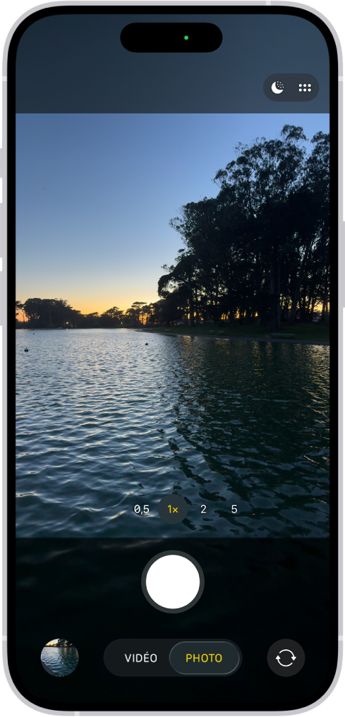 L’écran « Appareil photo » en mode Photo. Une scène de nuit apparaît dans le viseur. Les boutons Nuit et Commandes de la caméra se trouvent en haut à droite de l’écran. En bas de l’écran, de gauche à droite, se trouvent le bouton « Visualiseur de photos et vidéos », les modes Photo et Vidéo et le bouton « Sélecteur de caméra - face arrière ».