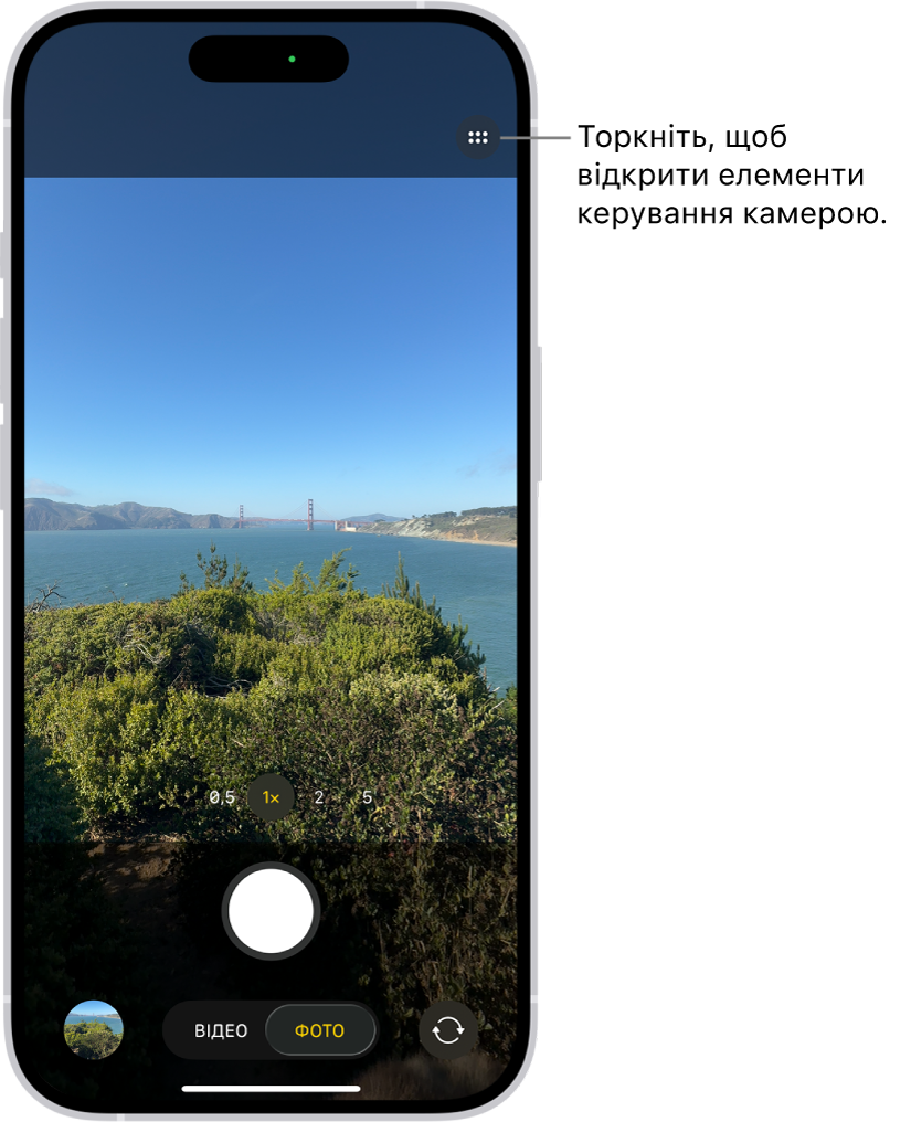Камеру відкрито в режимі «Фото». Кнопка «Елементи керування камерою» розташована у верхньому правому куті. Кнопка «Програма перегляду фото та відео» розташована в нижньому лівому куті. Унизу по центру — кнопка «Зробити знімок», а в нижньому правому куті — кнопка «Вибір задньої камери».