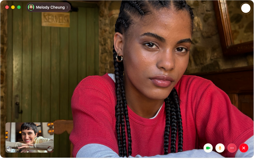 Fereastra FaceTime afișând un apel video. Persoana care a inițiat apelul este afișată într-o fereastră în colțul din dreapta jos. Celălalt participant apare în partea principală a ferestrei, alături de un buton Live Photo în colțul din dreapta sus, pe care apelanții pot face clic pentru a surprinde momentul.