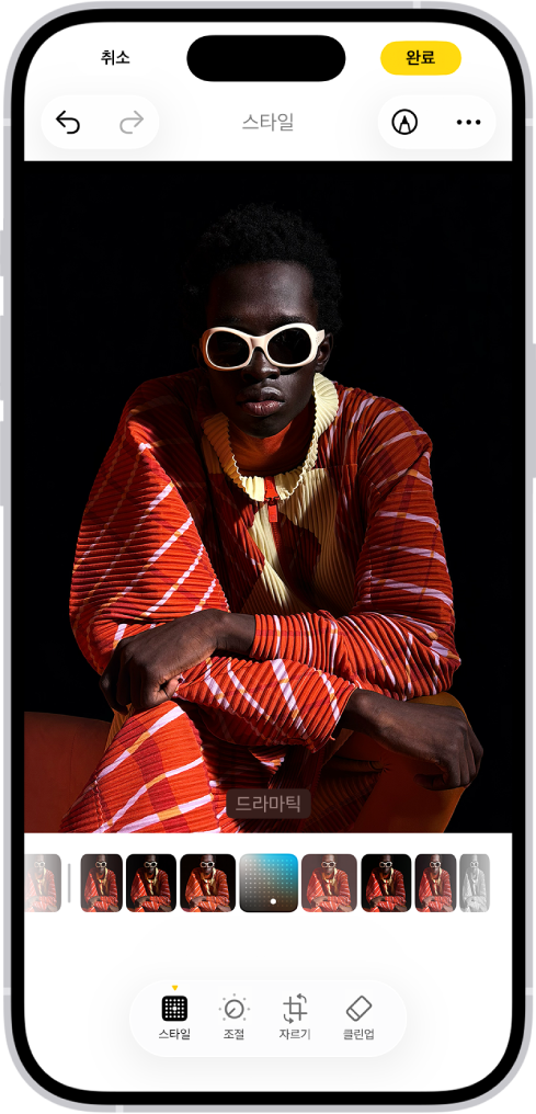 중앙에 사진이 있는 편집 화면. 화면 하단에는 왼쪽에서 오른쪽으로 스타일, 조절, 자르기 및 클린업 버튼이 있음. 스타일 버튼이 선택됨. 사진 아래에는 다양한 스타일 옵션이 있고, 드라마틱이 선택됨. 화면 왼쪽 상단 모서리에는 취소 버튼이 있고, 오른쪽 상단 모서리에는 완료 버튼이 있음.