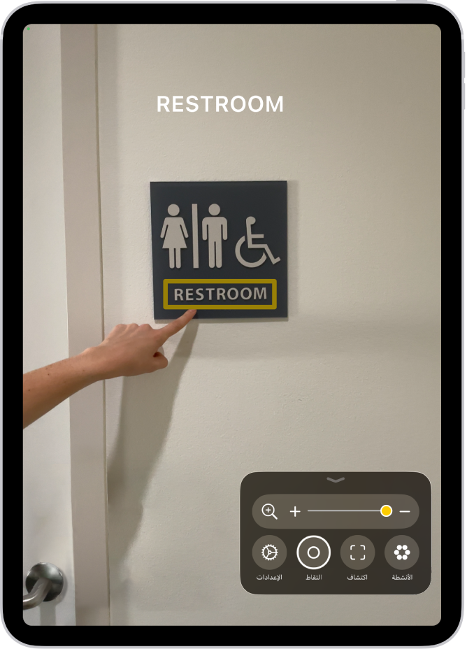 تطبيق المكبر يكتشف إصبعًا يشير إلى نص موجود على الحائط.