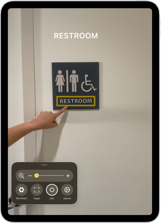 Büyüteç uygulaması bir duvardaki metni işaret eden parmağı algılıyor.