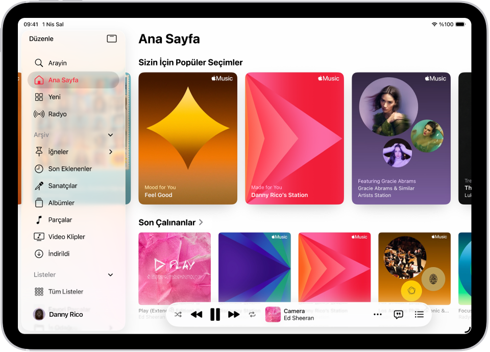 Müzik uygulamasının Ana Sayfa sekmesi, sol tarafta kenar çubuğunu, sağ tarafta ise Ana Sayfa bölümünü gösteriyor. En üstte Popüler Seçimler’i gösteren Ana Sayfa sekmesi. Alt tarafta son çalınan müzikler görünüyor ve dört albüm kapağı gösteriliyor. Mini çalar en altta.