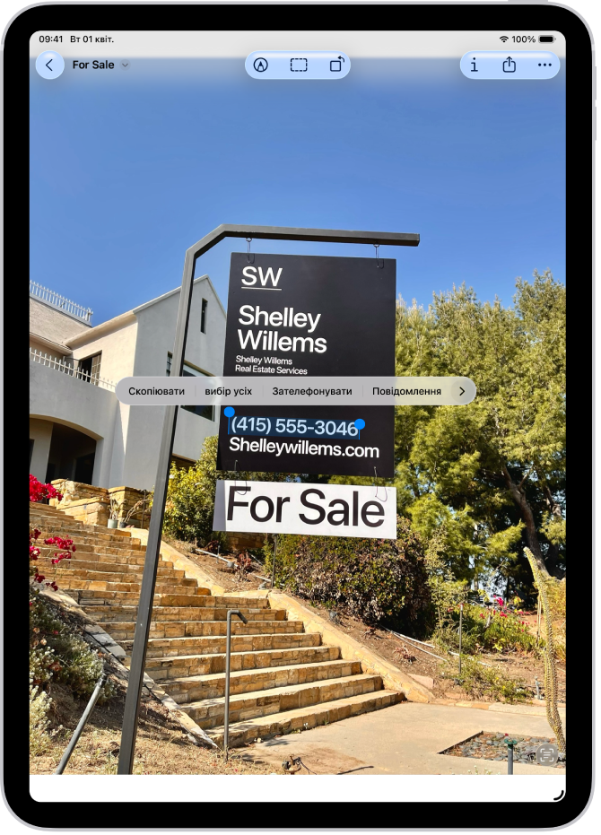Фотографія знака агенції нерухомості з виділеним номером телефону. Над номером телефону — опції «Виклик», «Повідомлення», «Додати до Контактів» і «Скопіювати».