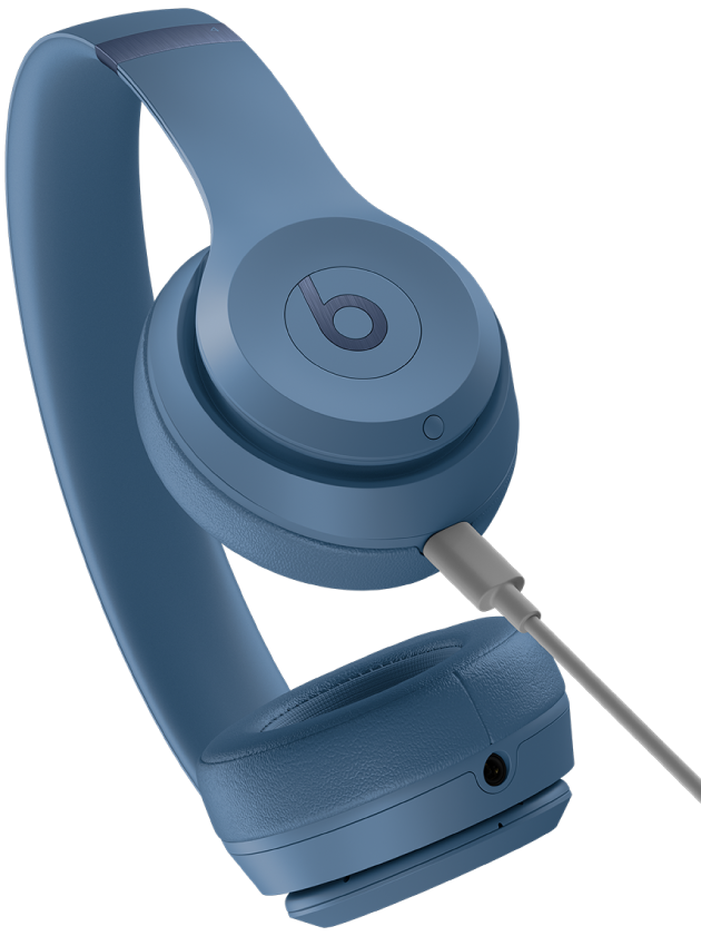 USB‑C kabel připojený k nabíjecímu portu na pravém sluchátku Beats Solo 4 (pod systémovým tlačítkem).