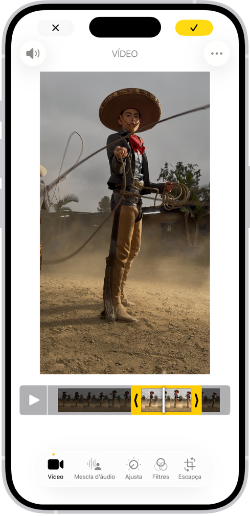 La pantalla d’edició de l’app Fotos en què s’està reproduint un vídeo al centre. Al visor de fotogrames de sota del vídeo se seleccionen els fotogrames (i se’n ressalten de color groc les vores) que s’inclouran al vídeo escurçat. A la part inferior de la pantalla hi ha els botons “Vídeo”, “Mescla d’àudio”, “Ajusta”, “Filtres” i “Escapça”; el botó “Vídeo” està seleccionat.