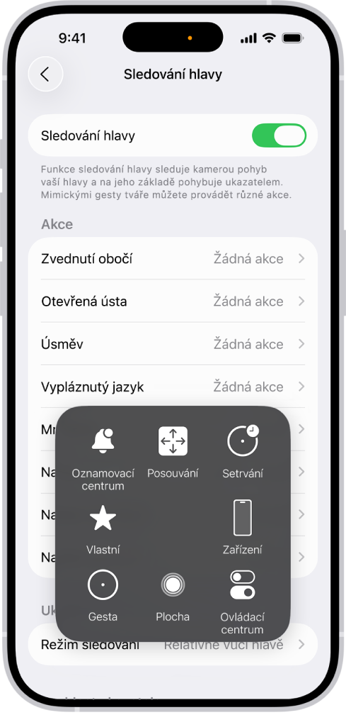 iPhone se zapnutým sledováním hlavy. Zobrazuje se nabídka AssistiveTouch obsahující ovládací prvky ve skupinách Oznamovací centrum, Posouvání, Setrvání, Zařízení, Ovládací centrum, Domácnost, Gesta a Vlastní.