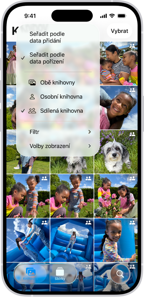 Sdílená knihovna fotek na iCloudu v aplikaci Fotky. V levém dolním rohu je vybráno tlačítko Sdílená knihovna a v seznamu možností knihovny je vybrána položka Sdílená knihovna. Všechny fotky zobrazené v knihovně mají v pravém horním rohu ikonu sdílené knihovny.