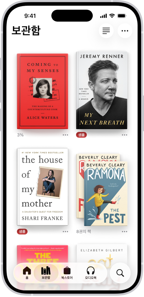 도서 앱의 보관함 화면. 화면 상단에는 모음 버튼이 있음. 화면 중간에는 책 표지가 있음. 화면 하단 왼쪽부터 오른쪽으로 홈, 보관함, 북스토어, 오디오북 및 검색 탭이 있음. 보관함 탭이 선택됨.