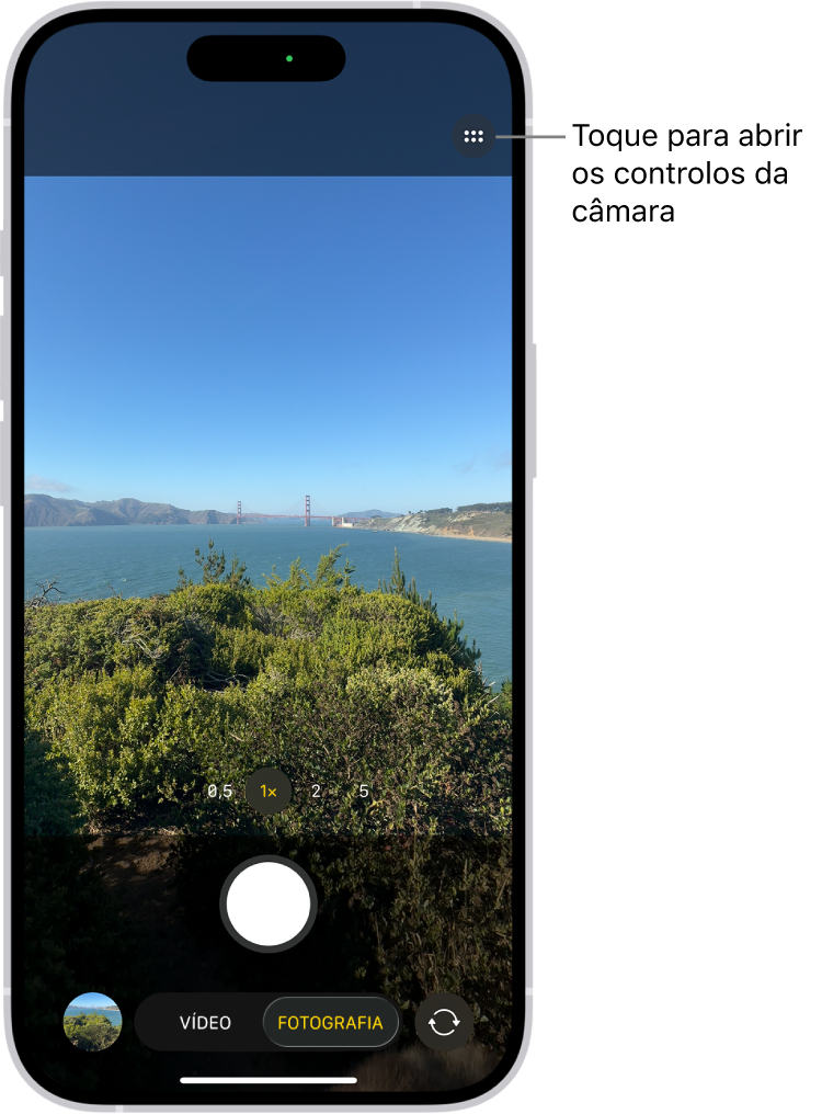 A aplicação Câmara está aberta no modo Fotografia. O botão “Controlos da câmara” está no canto superior direito. O botão do visualizador de fotografias e vídeos encontra‑se no canto inferior esquerdo. O botão para tirar fotografias encontra‑se na parte inferior do ecrã, ao centro, e o botão “Seletor da câmara - traseira” está no canto inferior direito.