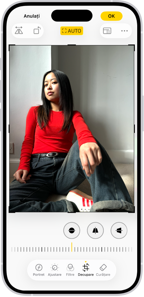 Ecranul Editați cu o poză în centru. În partea de jos a ecranului, de la stânga la dreapta, se află butoanele Portret, Ajustare, Filtre, Decupare și Curățare. Este selectat butonul Decupați și există un glisor pentru ajustarea îmbunătățirilor geometrice.