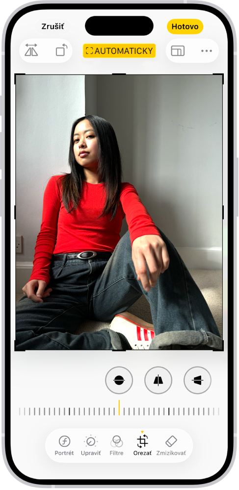 Obrazovka úprav s fotkou v stredu. V dolnej časti obrazovky sú zľava doprava umiestnené tlačidlá Portrét, Upraviť, Filtre, Orezať a Zmizíkovať. Tlačidlo Orezať je vybrané a zobrazuje sa posuvník na úpravu vylepšení geometrie.