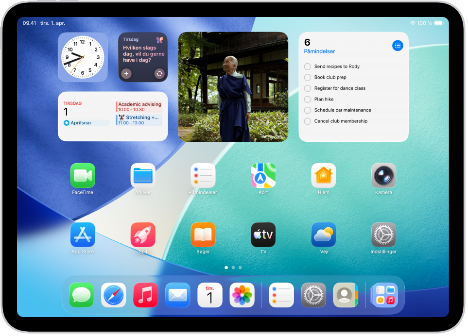 Hjemmeskærmen med Dock, der viser seks favoritapps til venstre og tre foreslåede apps til højre. Symbolet yderst til højre i Dock åbner Appbibliotek.