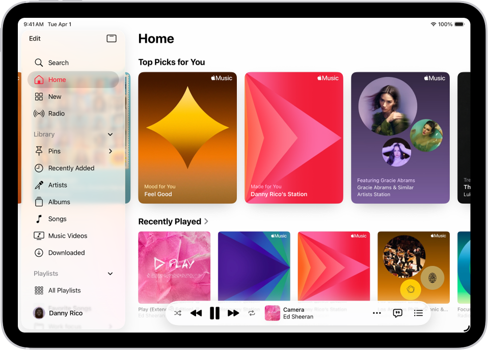 موسیقی ایپ میں ہوم ٹیب جس کے بائیں طرف سائڈ بار اور دائیں طرف ہوم سیکشن دکھایا گیا ہے۔ ہوم ٹیب میں اوپر ٹاپ پِک دکھائے گئے ہیں۔ حالیہ پلے کی گئی موسیقی نیچے دکھائی دیتی ہے جس میں البم کے چار سر ورق دکھائے گئے ہیں۔ نیچے MiniPlayer ہے۔
