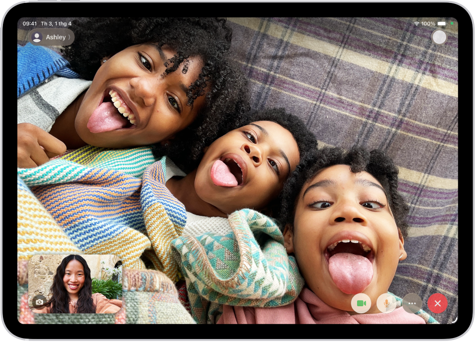 Một cuộc gọi FaceTime video đang diễn ra, đang hiển thị một người tham gia ở dưới cùng bên trái. Một hình ảnh gồm ba người tham gia khác phủ kín phần còn lại của màn hình. Ở dưới cùng bên phải là các nút Camera, Micrô, Thêm và Kết thúc cuộc gọi.