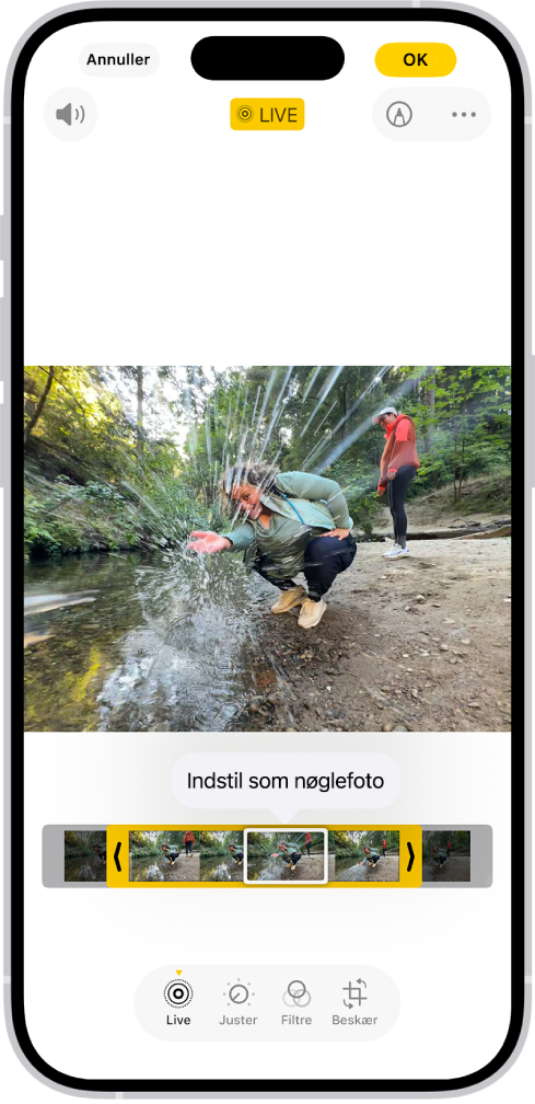 Et Live Photo er åbent i appen Fotos. Under fotoet vises billedfremviseren med knappen Indstil som nøglefoto aktiv. I hver ende af billedfremviseren er der to pile, som du kan bruge til at tilpasse dit Live Photo. Nederst på skærmen ses knapperne Live, Juster, Filtre og Beskær. Knappen Live er valgt.
