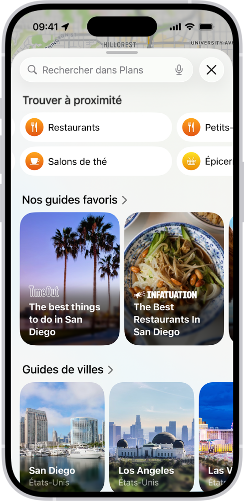 L’app Plans affichant le champ de recherche, des catégories de services à proximité ainsi que des guides touristiques. Le clavier à l’écran de l’iPhone apparaît dans la partie inférieure de l’app.