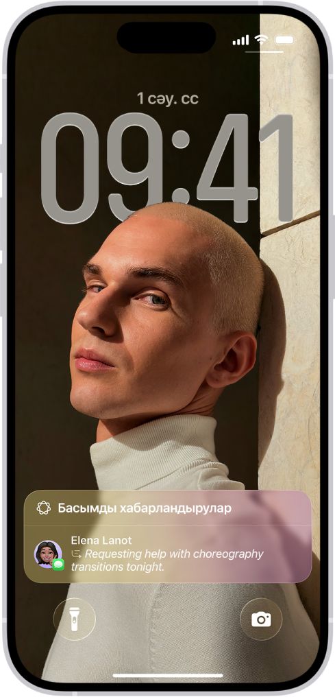 Құлыптау экранын көрсетіп тұрған iPhone. Экранның астыңғы жағында жинақтама ақпараты жасалған уақыты шектеулі хабарландыру көрсетіліп тұр.