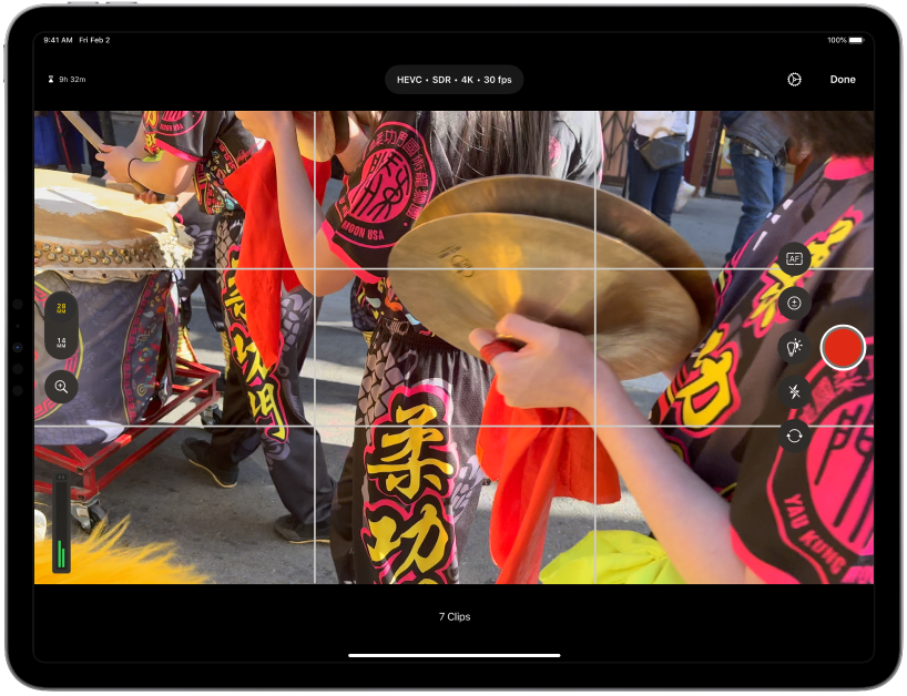 Lo schermo della videocamera registra un video di una sfilata variopinta.